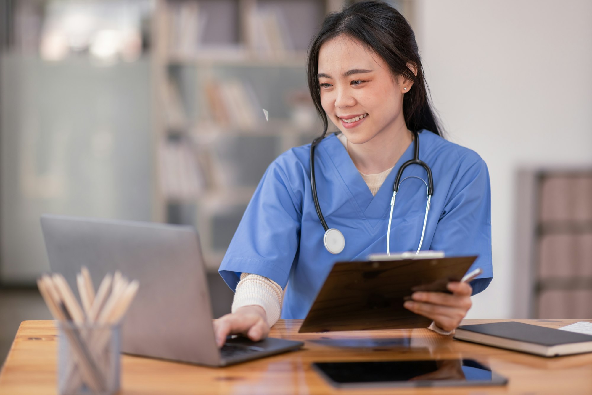portrait-of-young-asian-smiling-female-nurse-working-on-laptop-in-private-clinic-positive-emotional-3.jpg